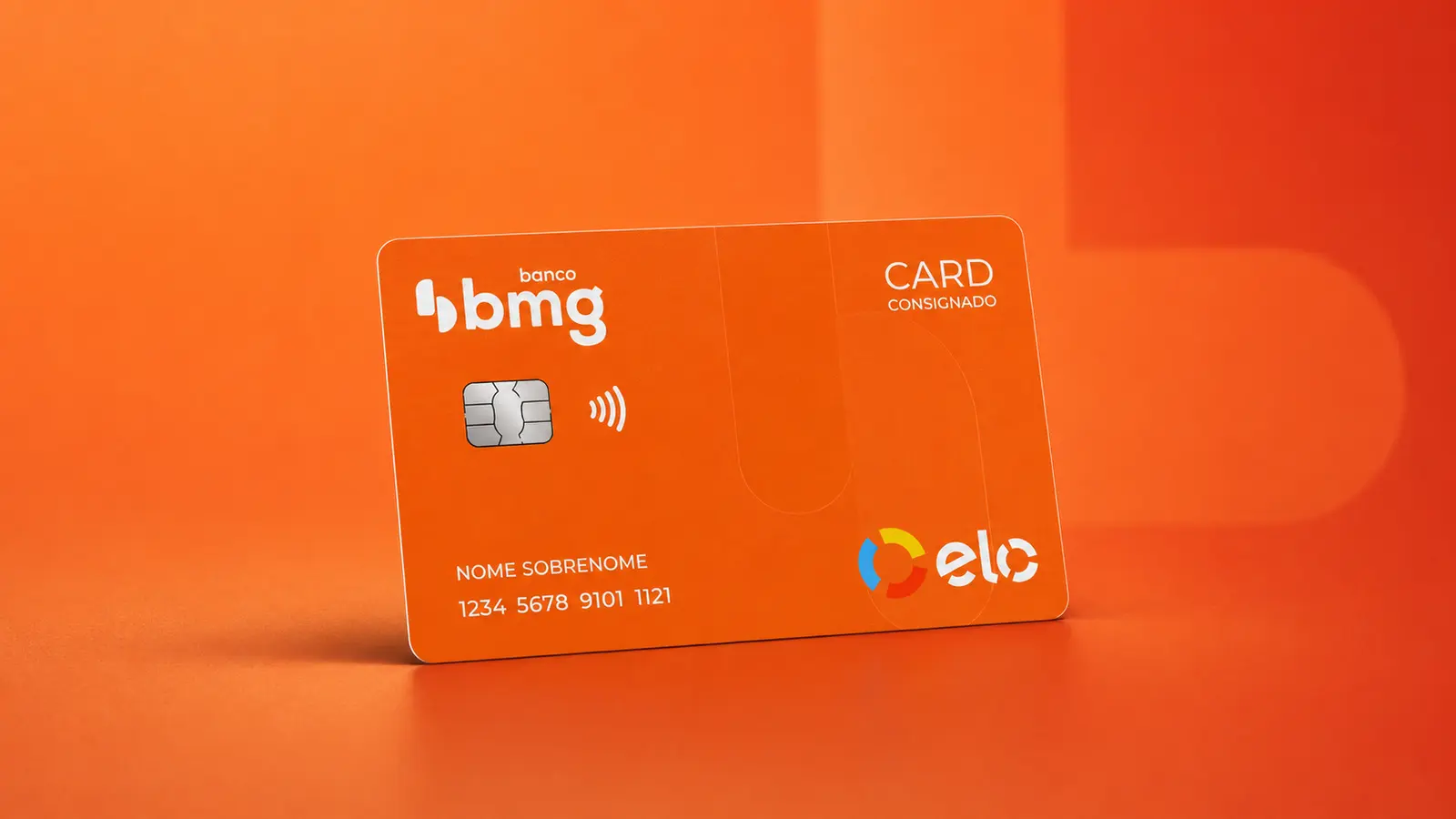 Cartão laranja do Banco Bmg com a inscrição Card Consignado, chip prateado e bandeira Elo, sobre fundo laranja