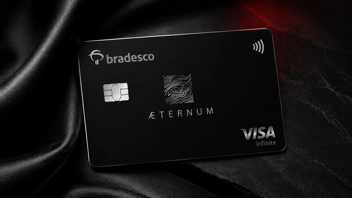 Cartão preto do Bradesco com a inscrição ÆTERNUM e o selo Visa Infinite, sobre tecido preto acetinado