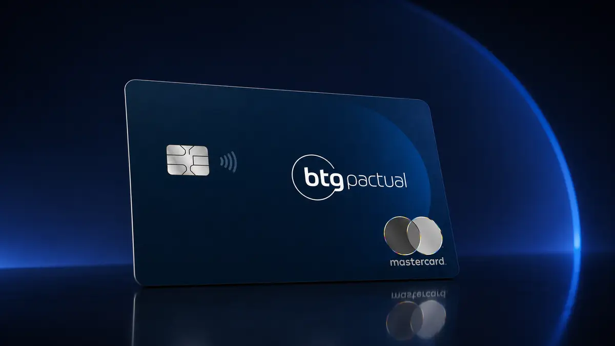 Cartão azul-marinho do BTG Pactual com chip prateado e logotipo Mastercard, sobre fundo escuro com halo azul