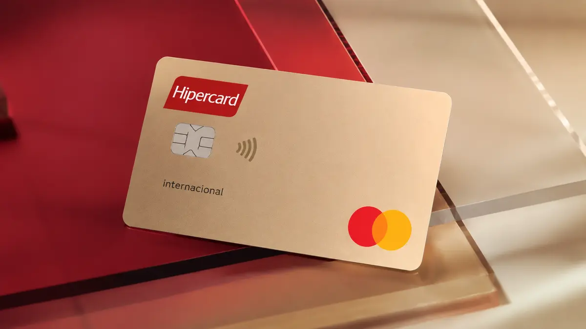 Cartão bege com o logotipo vermelho da Hipercard, a palavra internacional e o selo Mastercard, sobre fundo vermelho