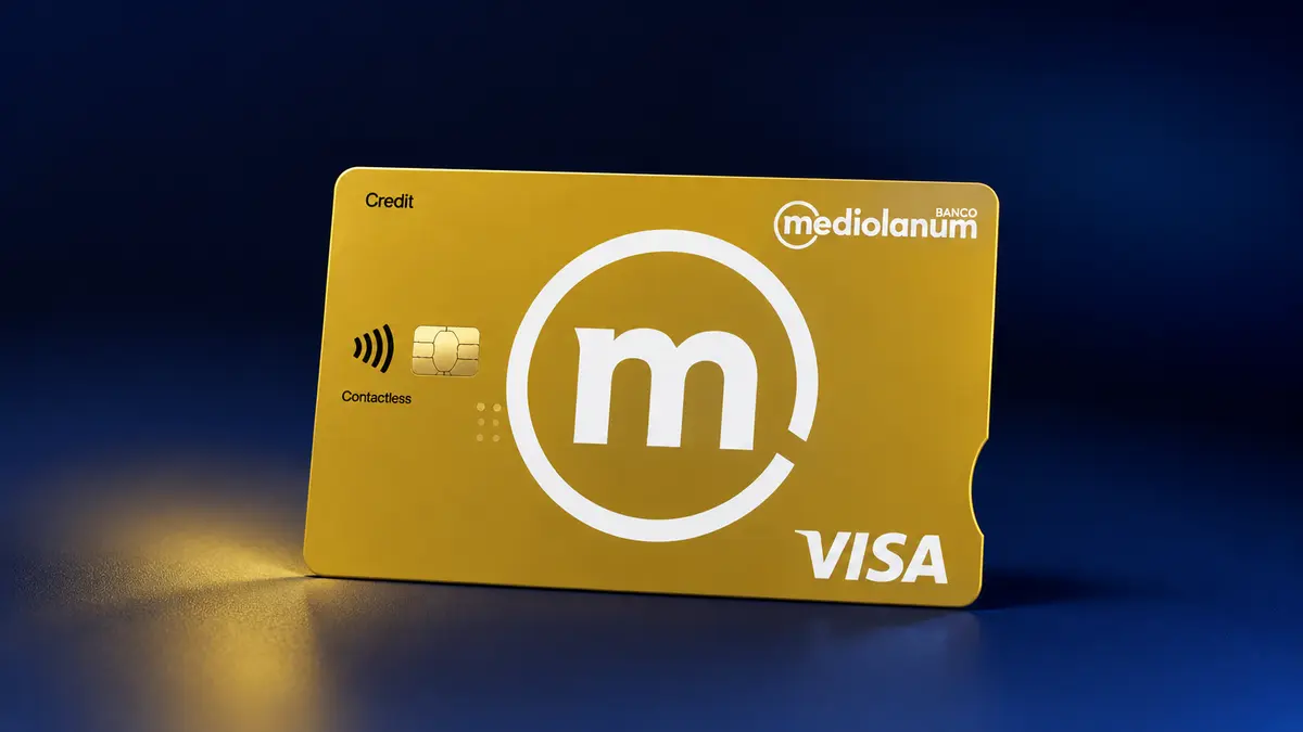Tarjeta dorada de Banco Mediolanum con la m blanca en círculo, chip, contactless y logotipo Visa sobre fondo azul