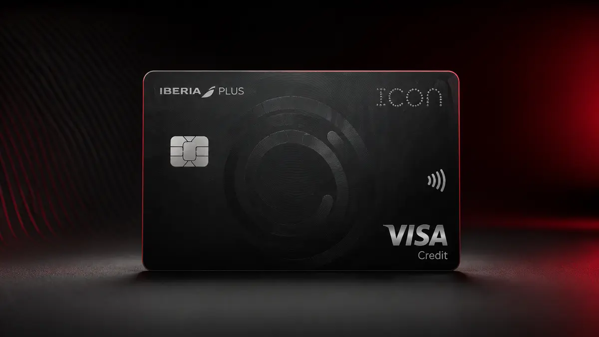 Tarjeta negra Iberia Plus Icon con el logotipo de Iberia, chip plateado y marca Visa Credit, sobre fondo rojo y negro